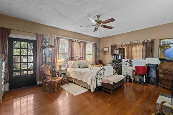 a spacious bedroom with a bed a couch and large window