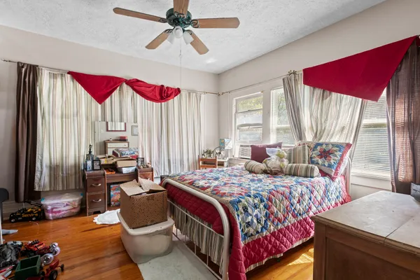 a bedroom with a bed and wooden floor