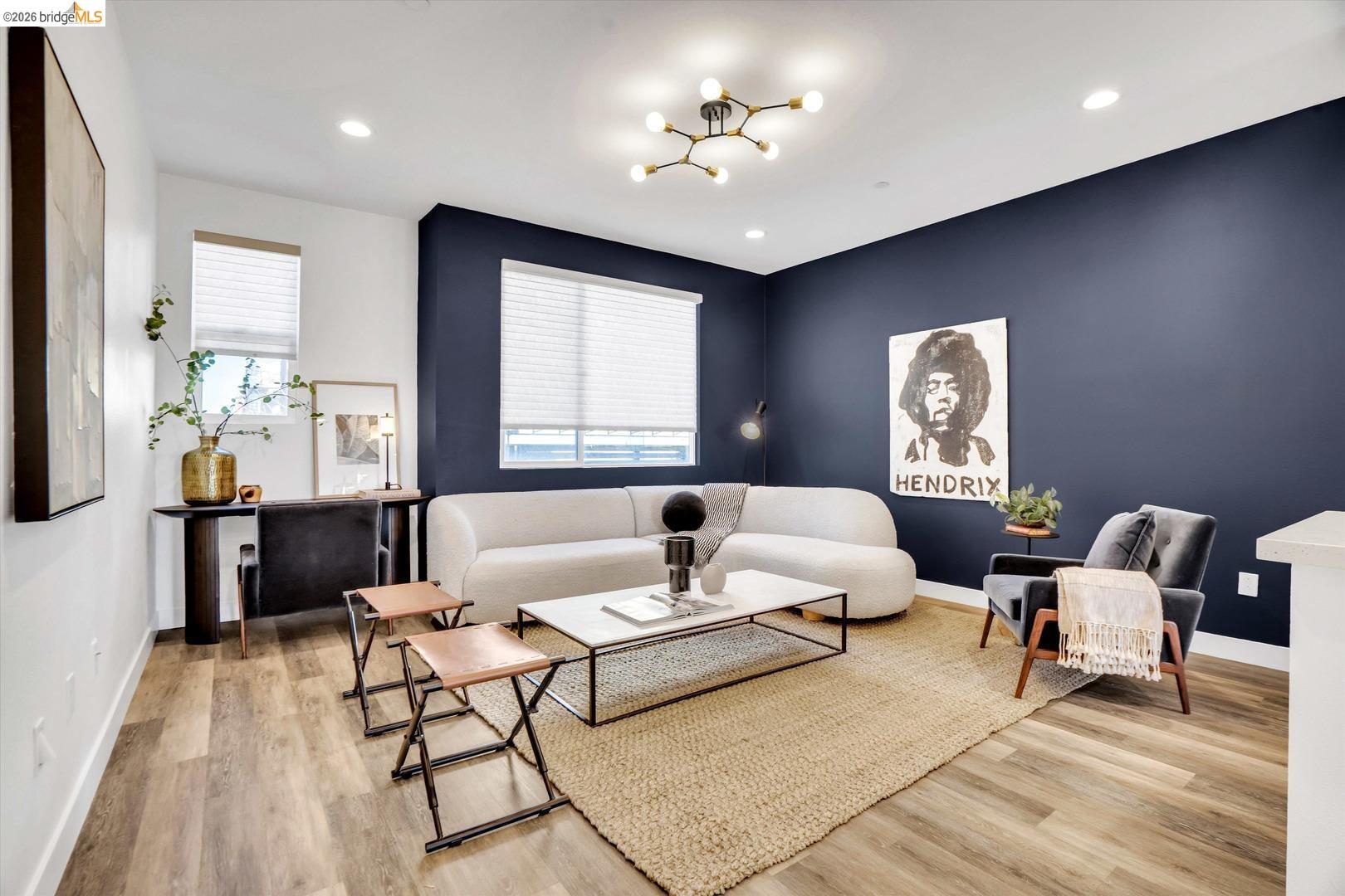 living room with light wood-style flooring and suspended lighting