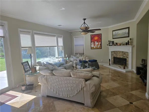 a living room with furniture a large window and a fireplace