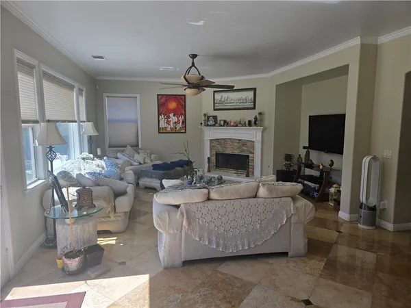 a living room with couches a flat screen tv and a fireplace