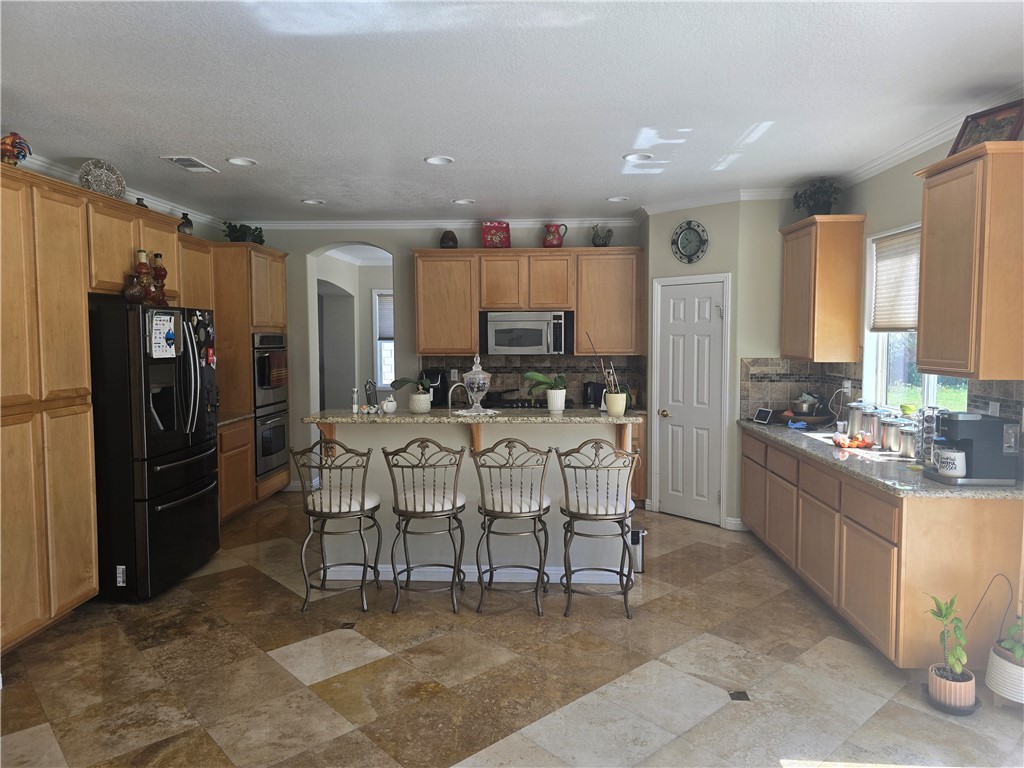 41740 Firenze Street Lancaster, CA 93536 - Photo 20 of 53 a kitchen with stainless steel appliances kitchen island granite countertop a sink and cabinets