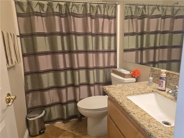 a bathroom with a granite countertop sink and vanity