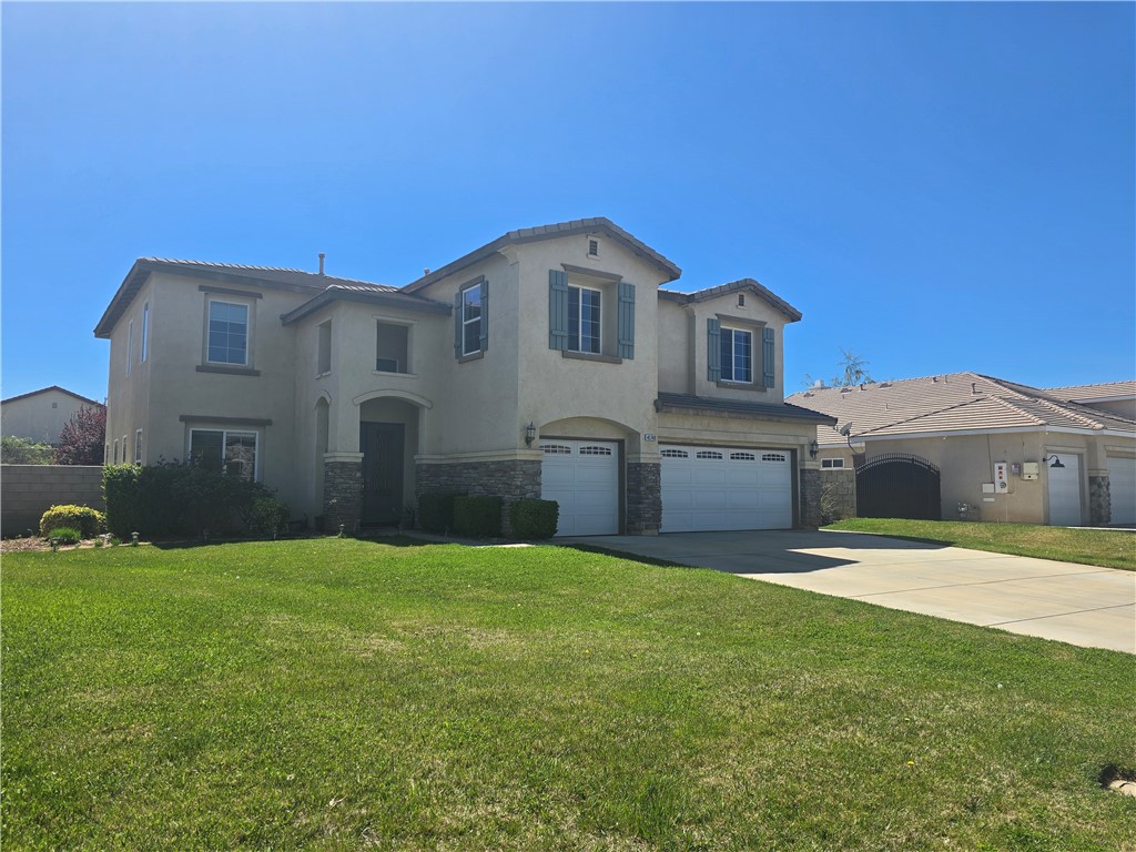 41740 Firenze Street Lancaster, CA 93536 - Photo 4 of 53 a front view of a house with a yard and garage