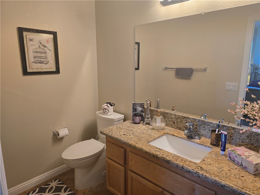 41740 Firenze Street Lancaster, CA 93536 - Photo 48 of 53 a bathroom with a granite countertop sink a toilet and mirror