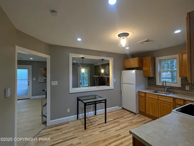 a kitchen with stainless steel appliances granite countertop a sink a stove and refrigerator