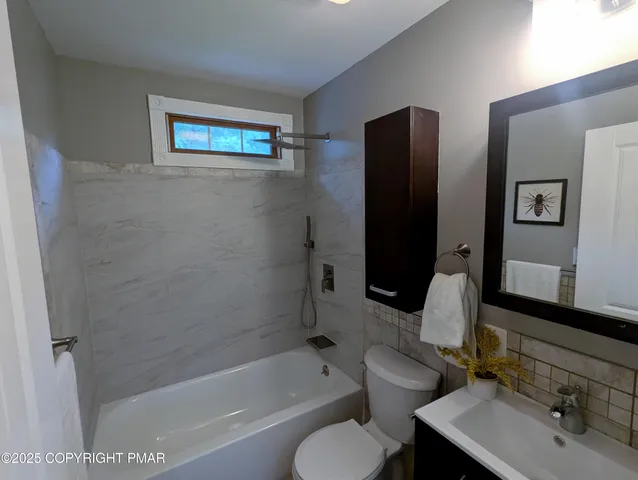 a bathroom with a bathtub shower sink and toilet