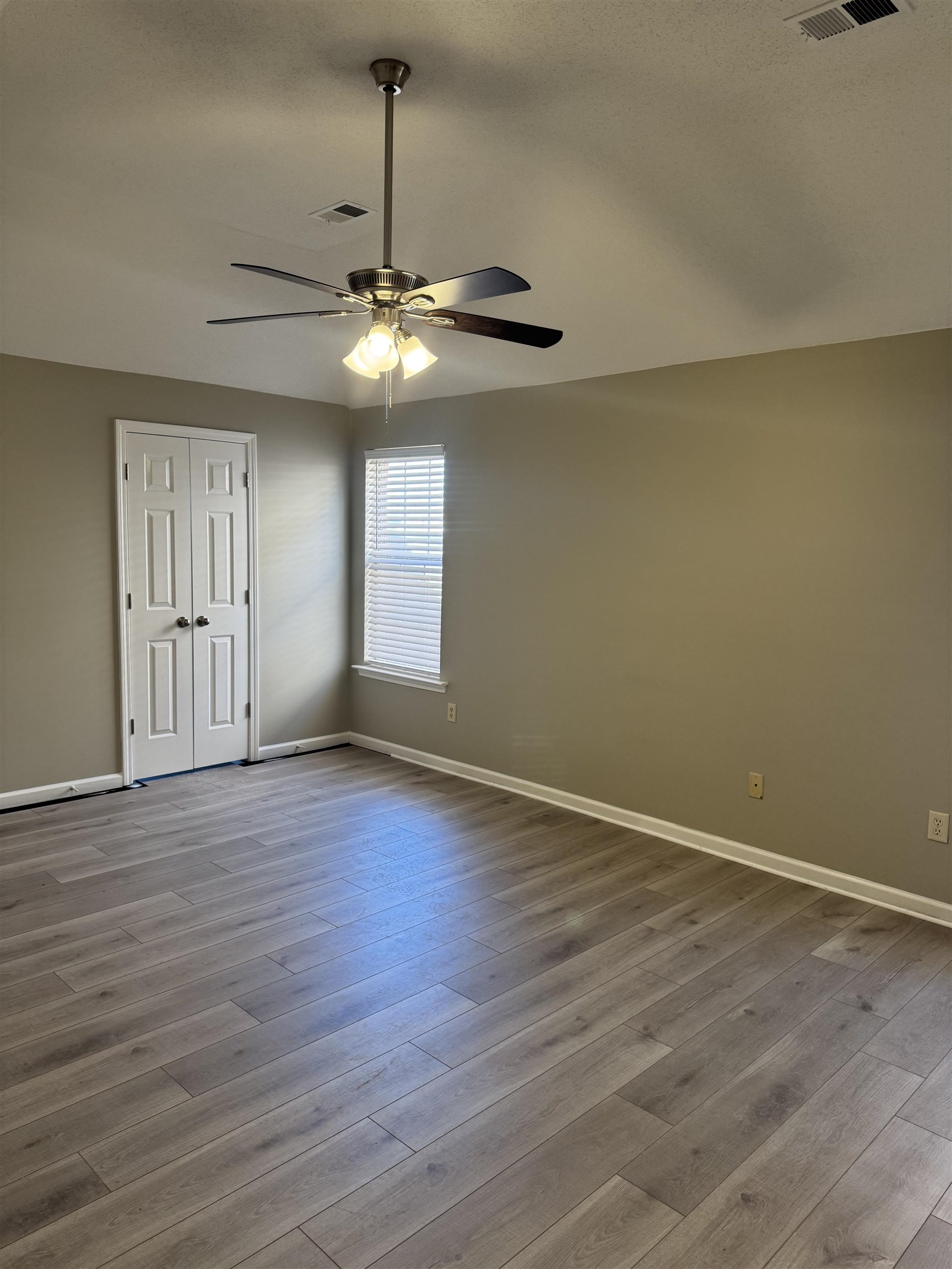 4929 Whitfall Cove South Memphis, TN 38125 - Photo 13 of 22 an empty room with wooden floor chandelier and windows