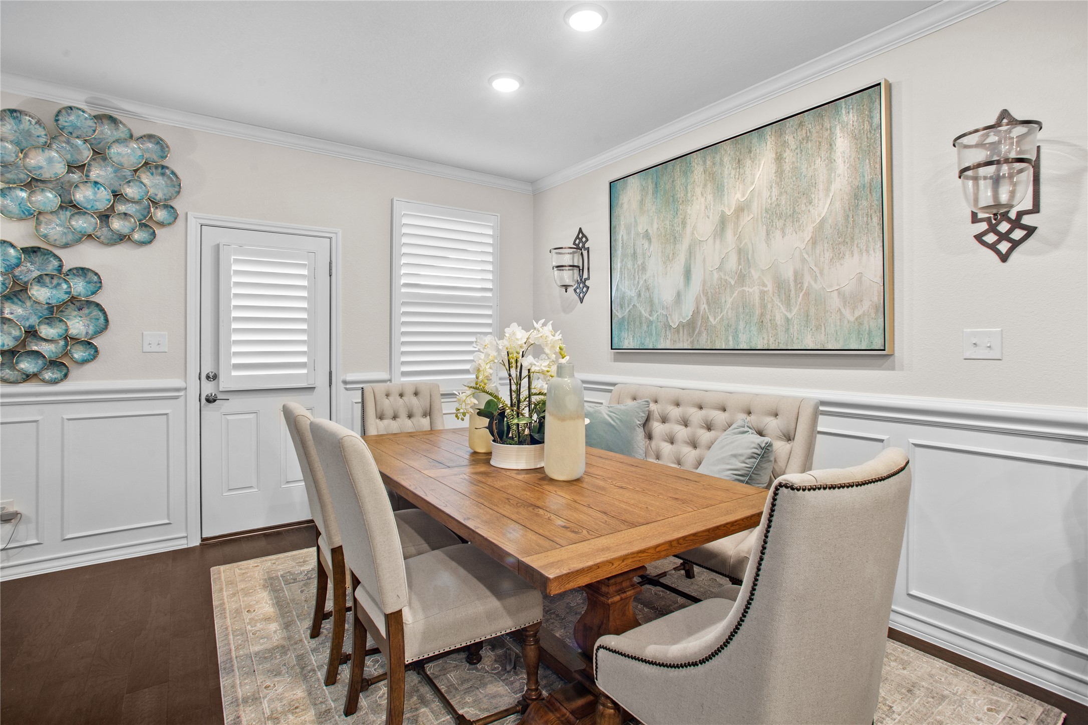 109 Adeline Road Hutto, TX 78634 - Photo 13 of 40 Dining area featuring wainscoting, a decorative wall, crown molding, and dark wood-style floors