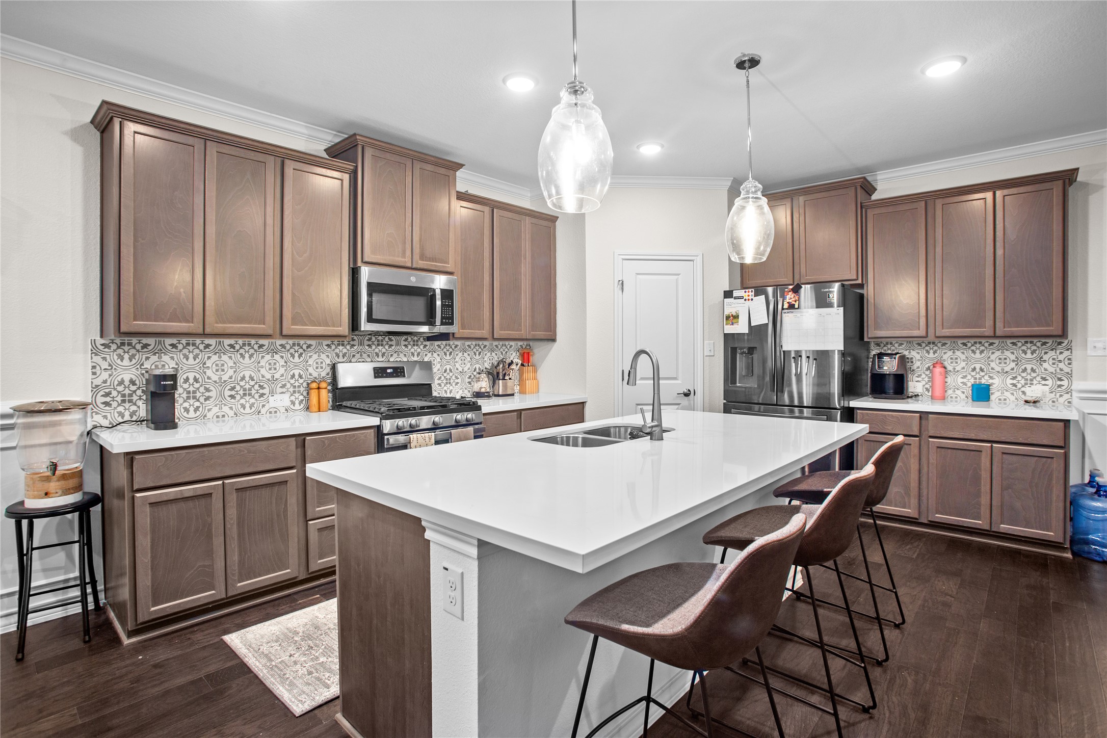 109 Adeline Road Hutto, TX 78634 - Photo 14 of 40 Kitchen with a kitchen breakfast bar, stainless steel appliances, an island with sink, dark wood-type flooring, and pendant lighting
