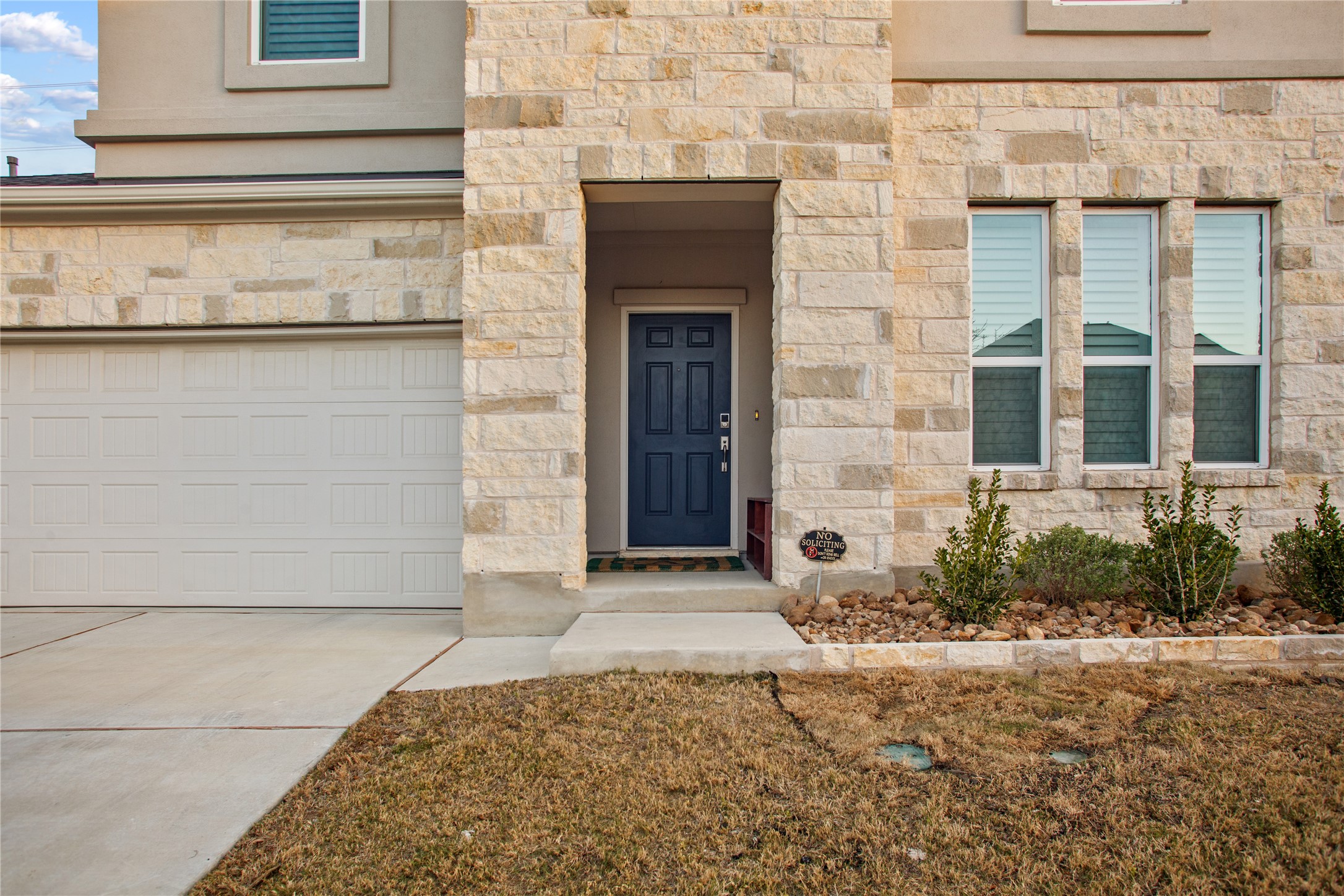 109 Adeline Road Hutto, TX 78634 - Photo 2 of 40 View of exterior entry featuring stone siding, concrete driveway, and an attached garage