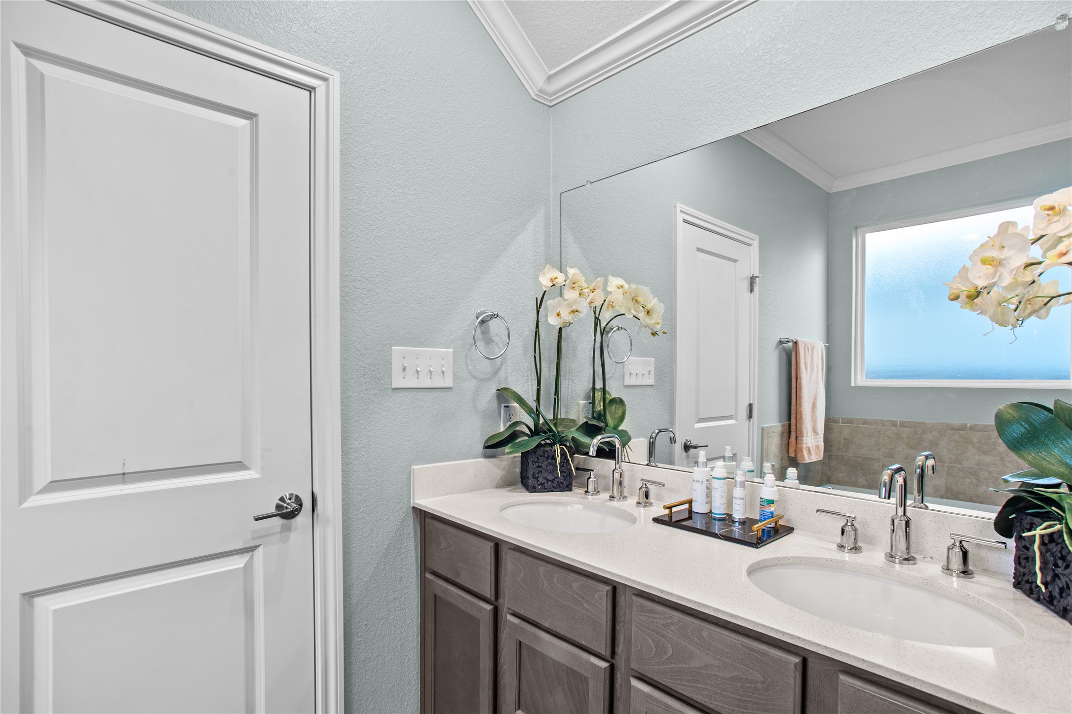 109 Adeline Road Hutto, TX 78634 - Photo 21 of 40 Full bathroom featuring double vanity, a textured wall, and crown molding