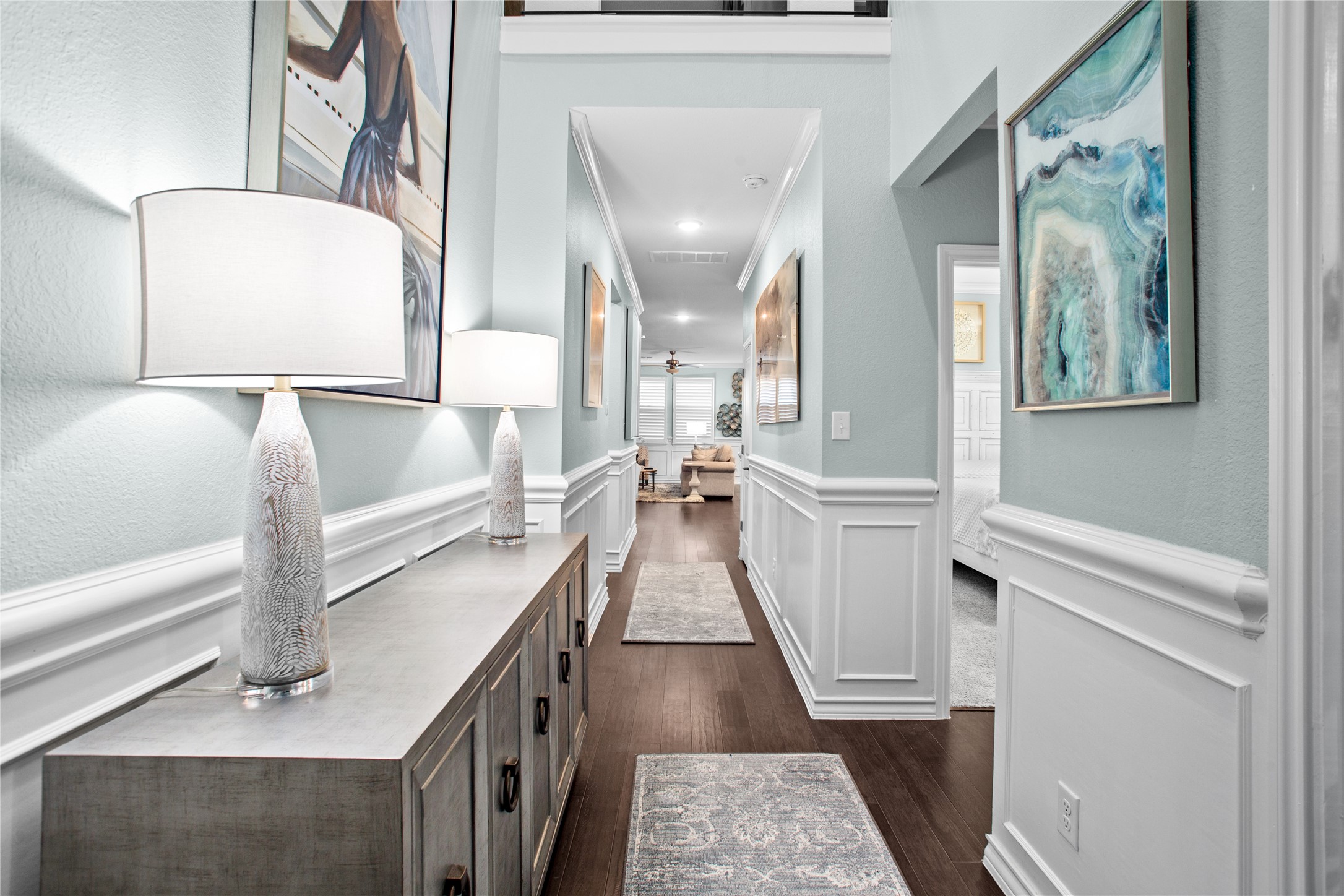 109 Adeline Road Hutto, TX 78634 - Photo 27 of 40 Hallway featuring dark wood-type flooring, wainscoting, crown molding, a decorative wall, and recessed lighting