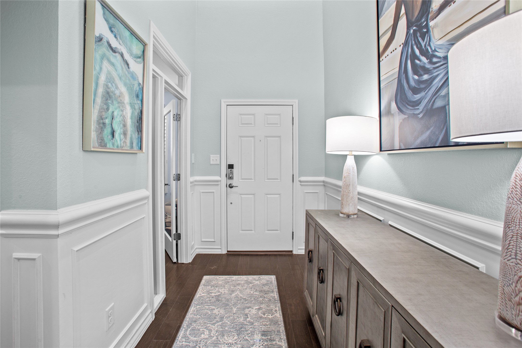 109 Adeline Road Hutto, TX 78634 - Photo 3 of 40 Entryway with a wainscoted wall, a decorative wall, and dark wood-type flooring
