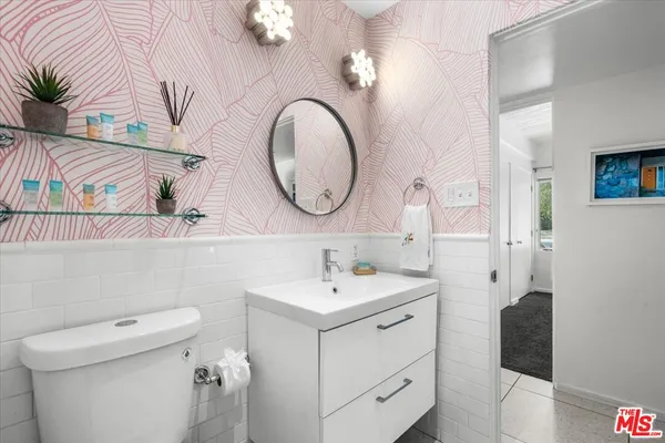 a bathroom with a sink a toilet and a mirror