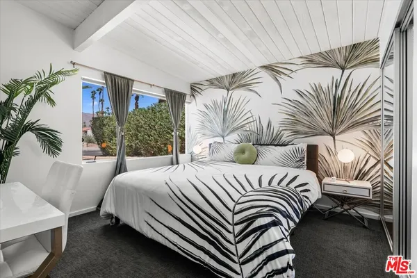 a bedroom with a bed lamp and a potted plant