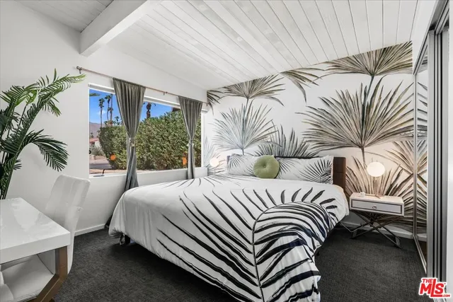 a bedroom with a bed lamp and a potted plant