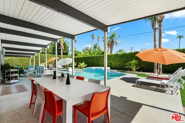 a view of a patio with a table and chairs under an umbrella