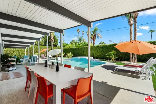 a view of a patio with a table and chairs under an umbrella