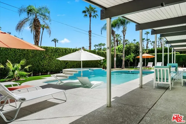 a view of a patio with a table and chairs under an umbrella
