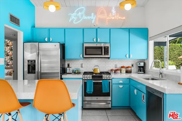 a kitchen with stainless steel appliances a stove microwave and sink