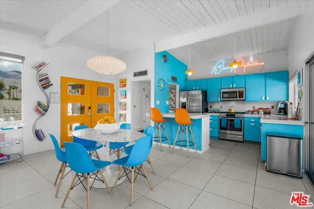 a view of a dining room with furniture a kitchen and chandelier