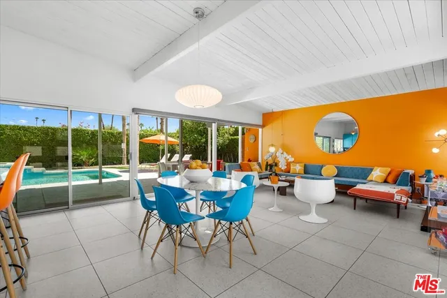 a dining room with furniture and a large window