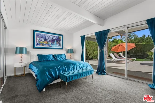 a bedroom with a bed and a painting on the wall