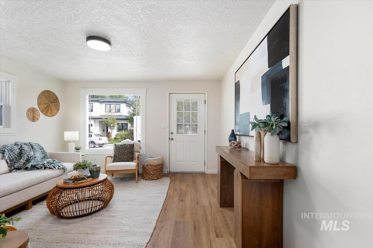 3005 West Hester Street Boise, ID 83702 - Photo 8 of 32 Living area featuring wood-finish flooring, white walls, and a large front window
