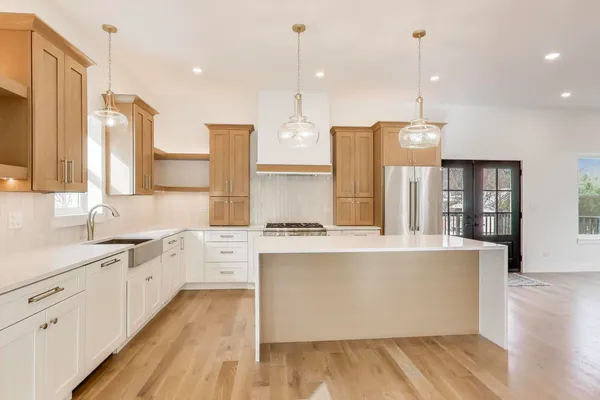 a large kitchen with cabinets wooden floor and a sink