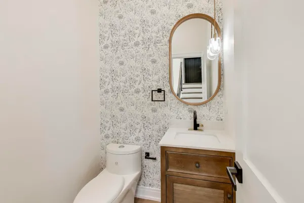 a bedroom with a bed large window couch and a chandelier