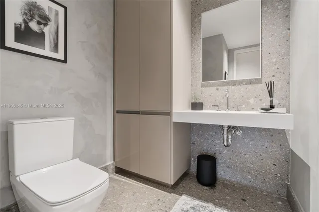 a bathroom with a toilet a sink and mirror