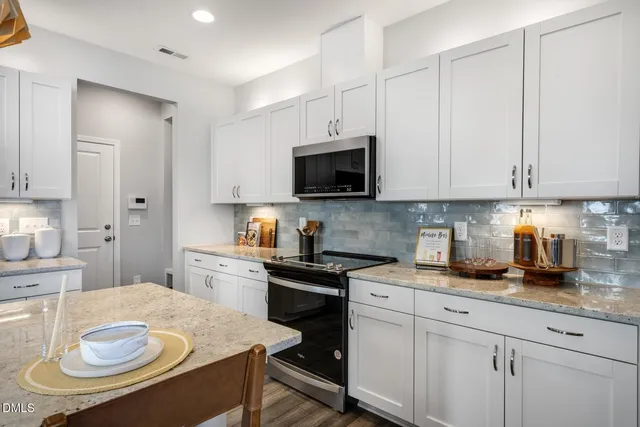 a kitchen with white cabinets stainless steel appliances and sink