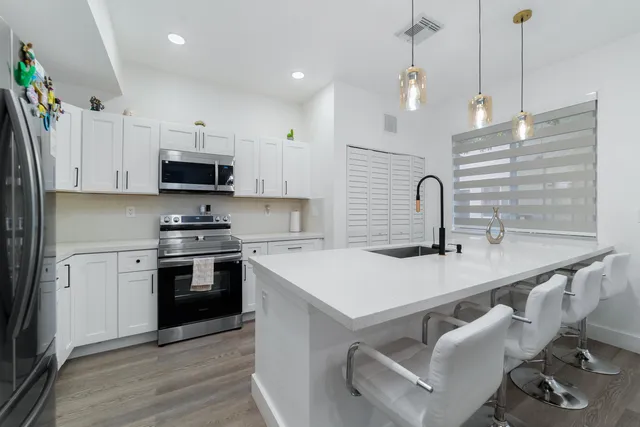 a kitchen with kitchen island a sink appliances and cabinets