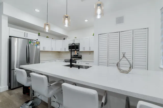 a kitchen with refrigerator and chairs