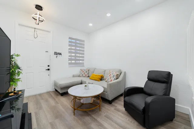 a living room with furniture and wooden floor