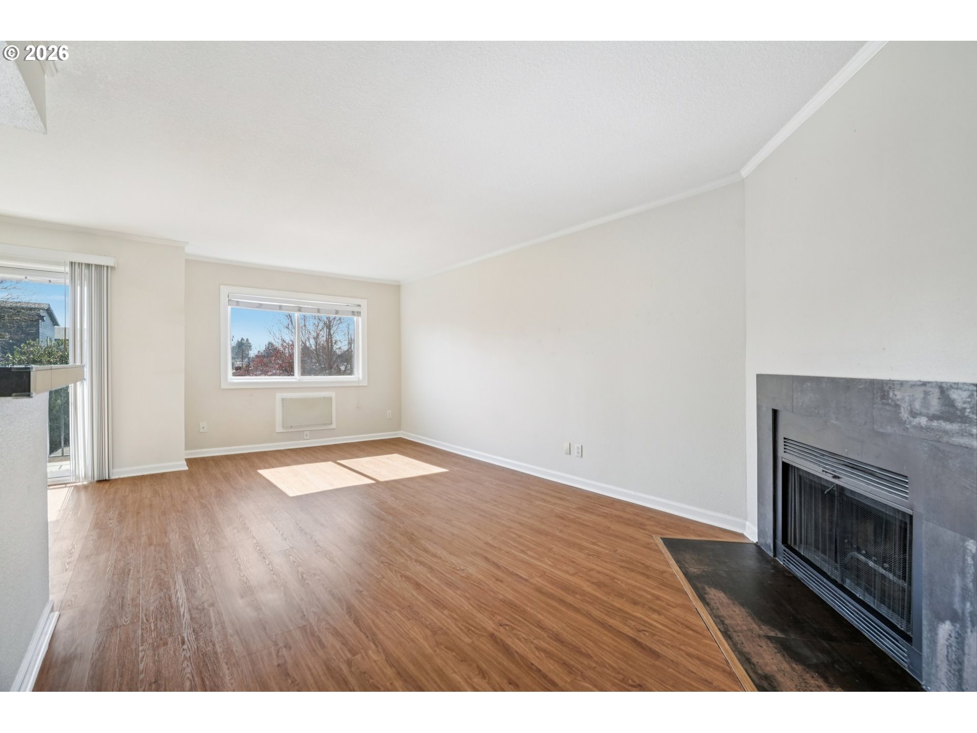 6600 Southeast Division Street, Unit 305 Portland, OR 97206 - Photo 4 of 34 a view of an empty room with wooden floor and a window