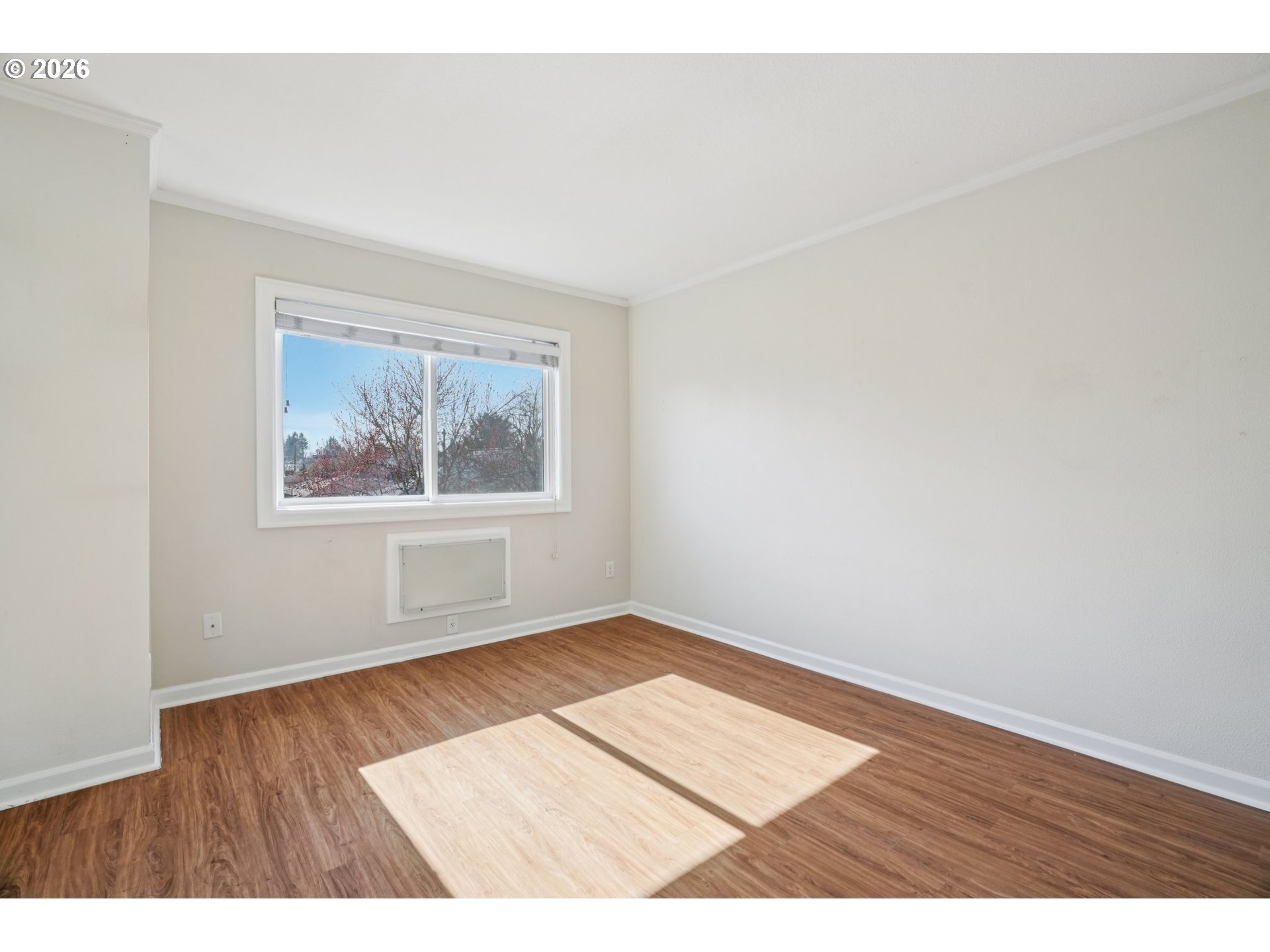 6600 Southeast Division Street, Unit 305 Portland, OR 97206 - Photo 5 of 34 an empty room with wooden floor and painting on the wall
