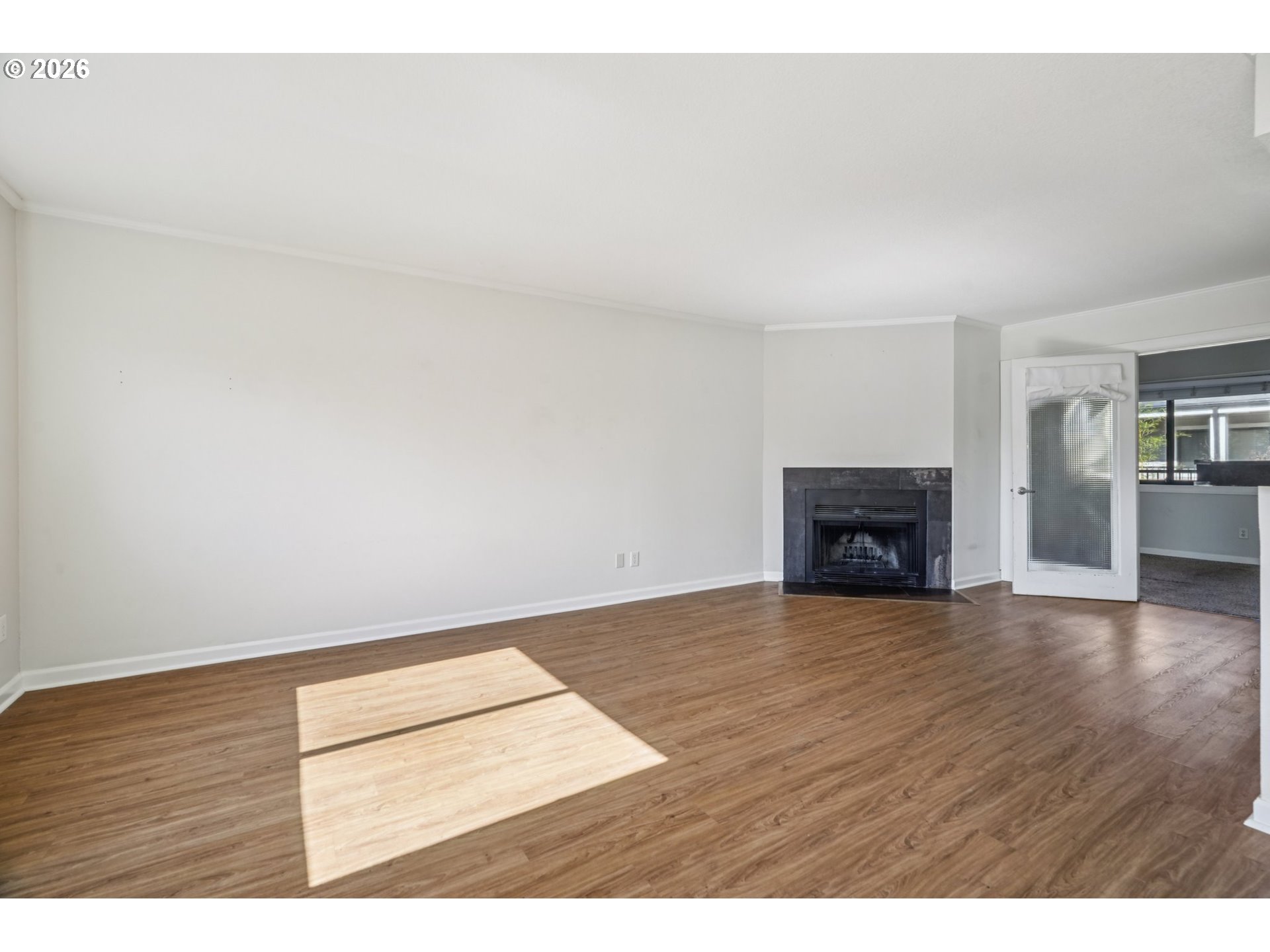 6600 Southeast Division Street, Unit 305 Portland, OR 97206 - Photo 7 of 34 a view of an empty room with wooden floor and a fireplace
