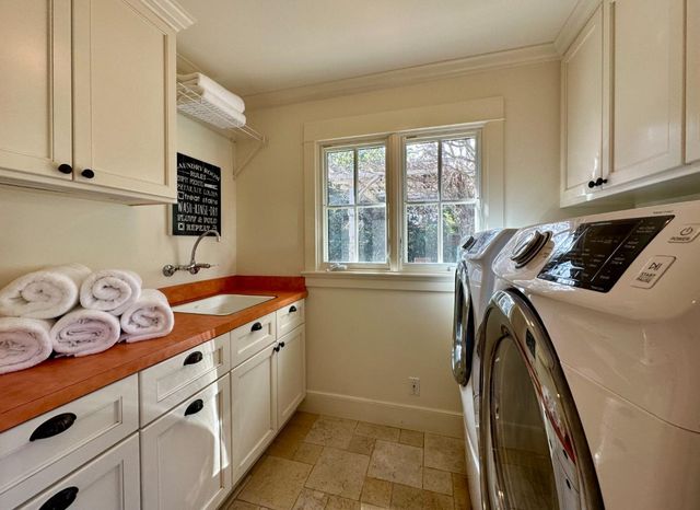 a utility room with cabinets washer and dryer