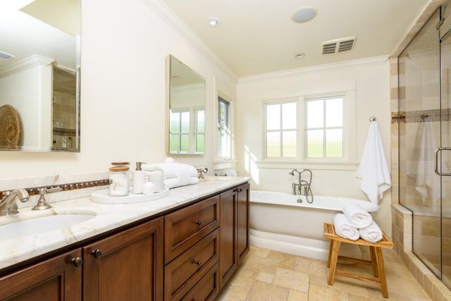a bathroom with a sink double vanity granite tub shower and a mirror