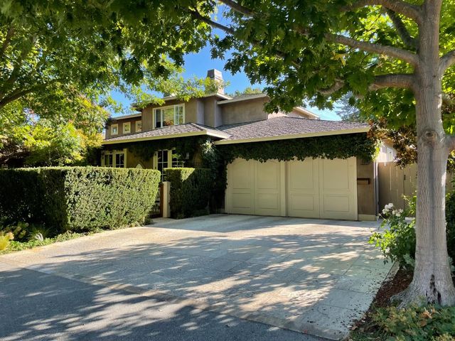 a front view of a house with a garden and garage