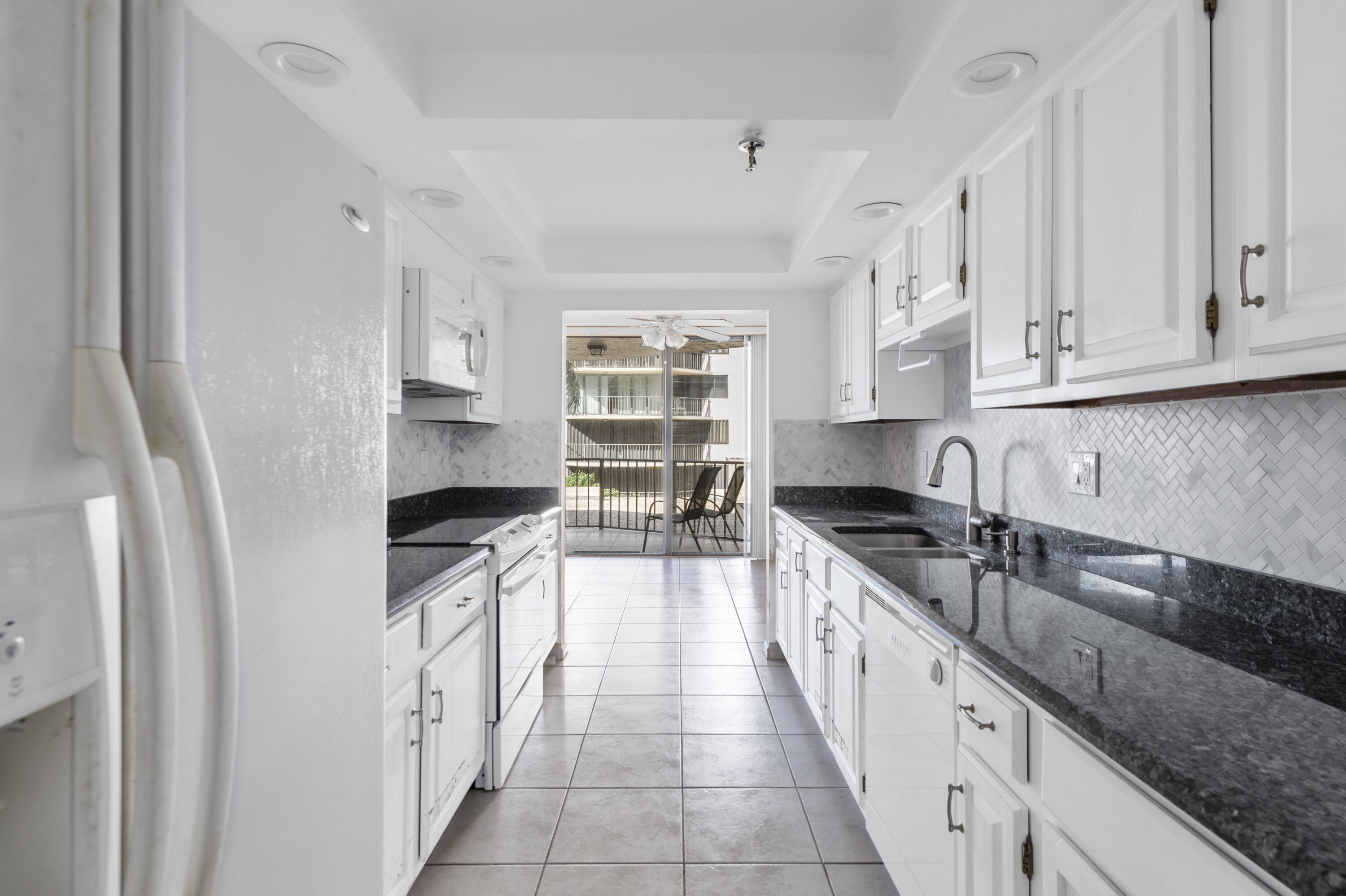 859 Jeffery Street, Unit 312 Boca Raton, FL 33487 - Photo 3 of 53 a kitchen with granite countertop a sink stove and cabinets