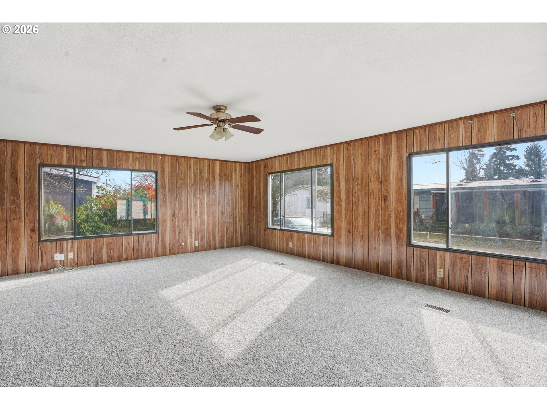 34931 Jackson Way, Unit 36 Scappoose, OR 97056 - Photo 4 of 35 a view of an empty room with a window and wooden floor
