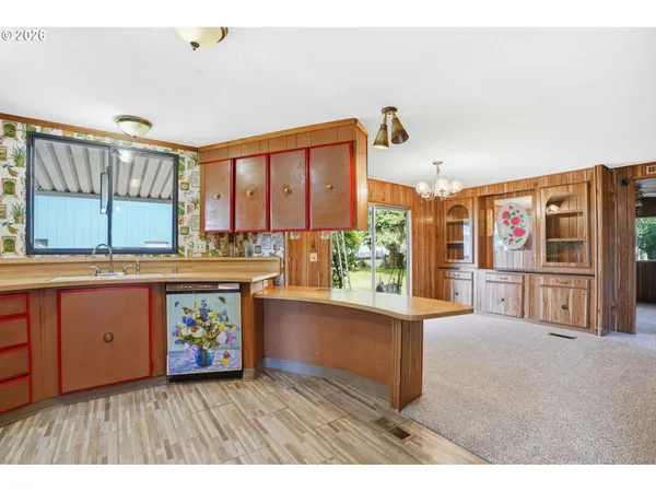 a kitchen that has a lot of cabinets a sink and a wooden floor in it