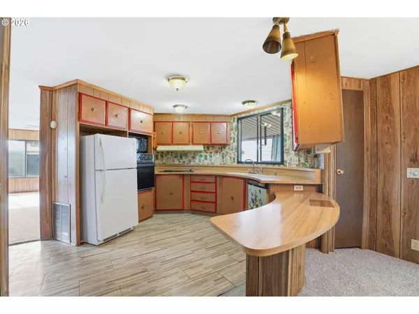 a kitchen with stainless steel appliances granite countertop a sink refrigerator and cabinets