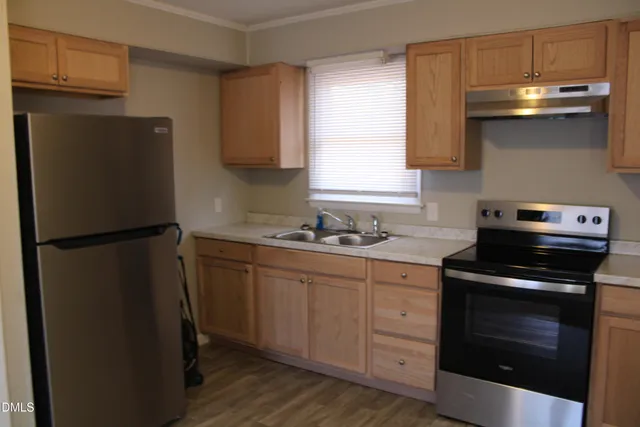 a kitchen with a refrigerator sink and cabinets