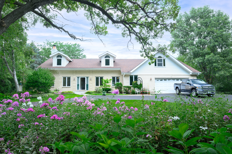 a front view of a house with a big yard and potted plants