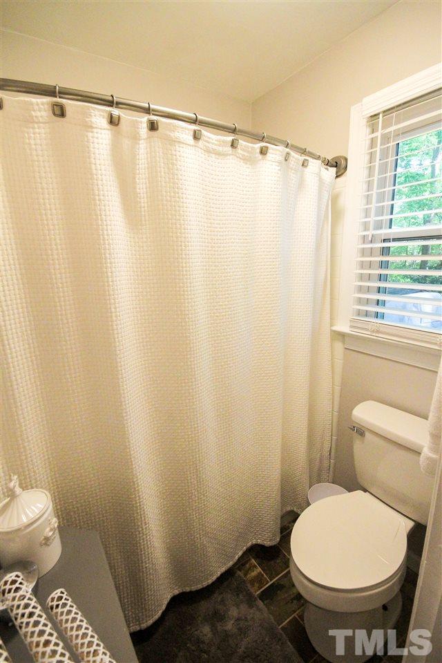 8212 Hambledon Court Raleigh, NC 27615 - Photo 16 of 28 a bathroom with a toilet and a shower curtain