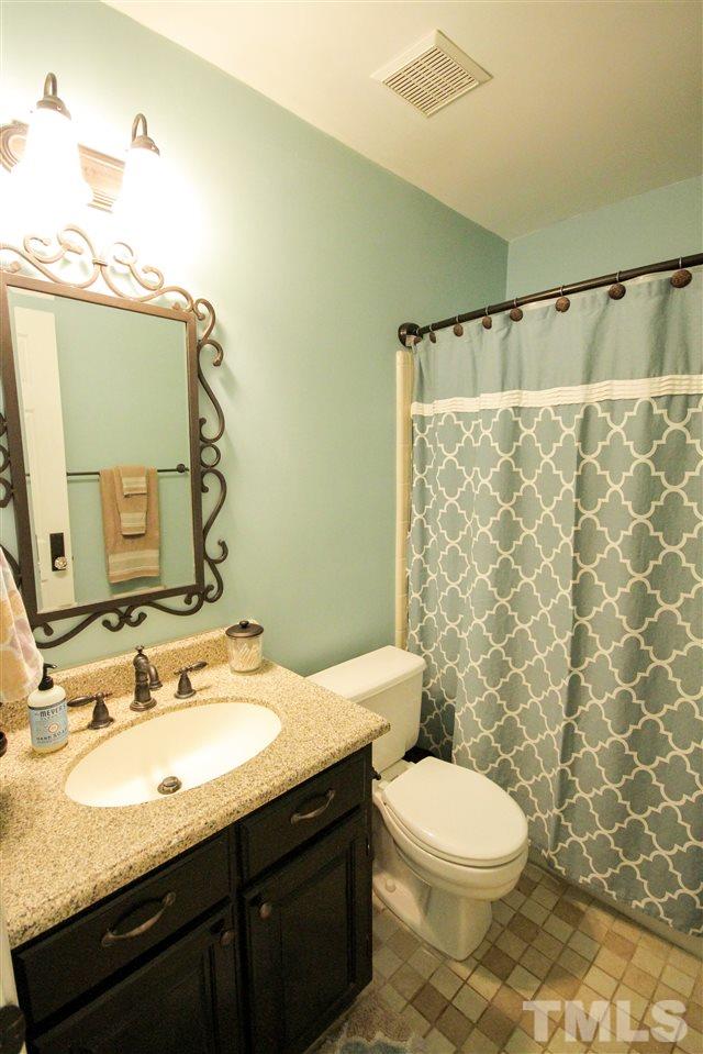 8212 Hambledon Court Raleigh, NC 27615 - Photo 18 of 28 a bathroom with a granite countertop sink toilet and shower